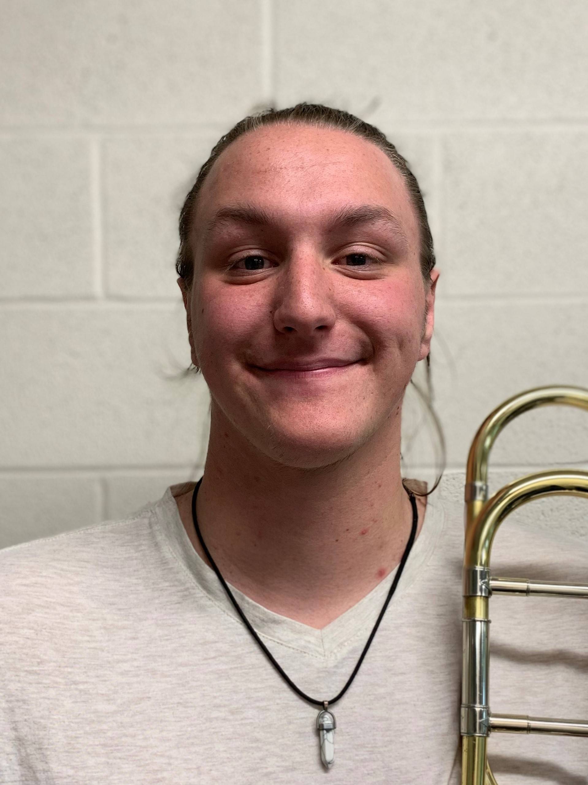 Flynn Brinks holding a tenor trombone